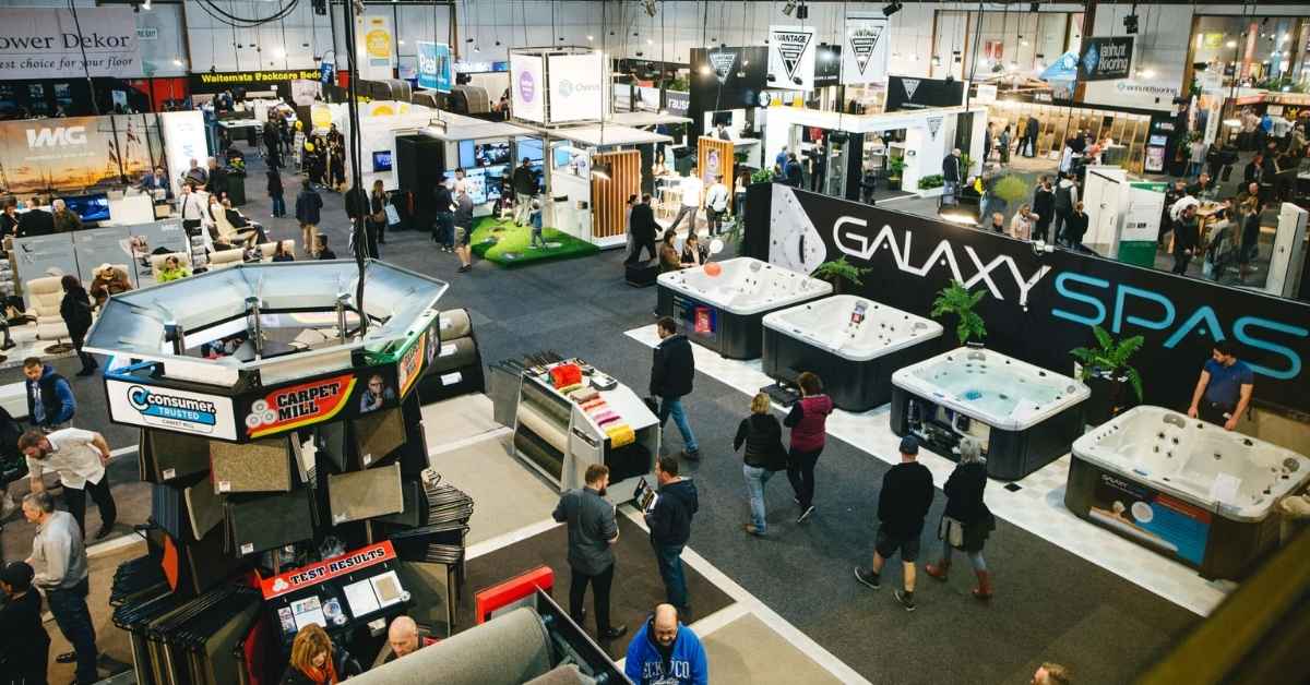 A bustling trade show floor with various booth design showcasing products. Visitors walk around, exploring exhibits.