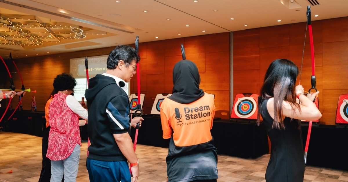 Dream Station staff instructs an attendee at a game booth