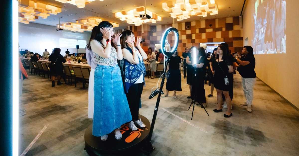 A group of event attendees partcipate in a 360 degree video booth