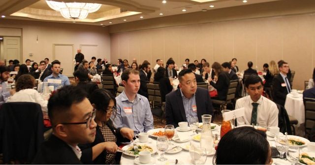 An overview of a company dinner and dance with attendees dressing in formal outfits