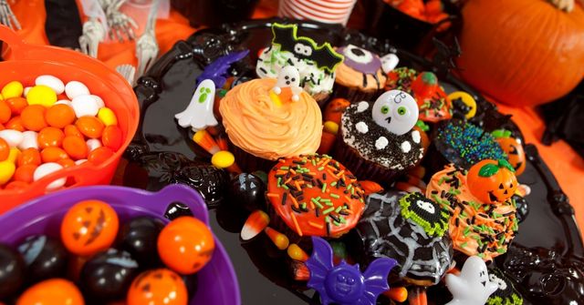 A table of Halloween-inspired snacks and treats at an adult Halloween party