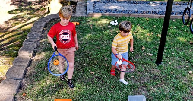 Two children are competing in a Pumpkin Relay Race at a Halloween party