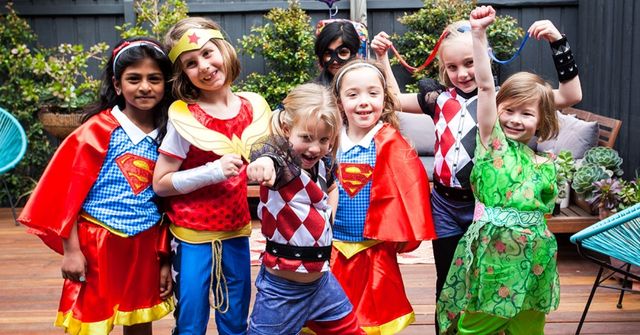Group photo of kids dressing up as superheros at a Halloween party