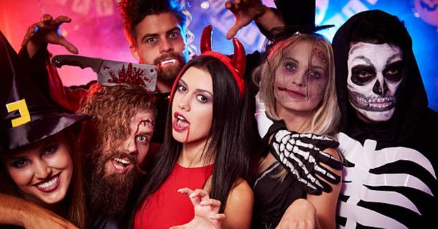 A group of Halloween party attendees pose for photos