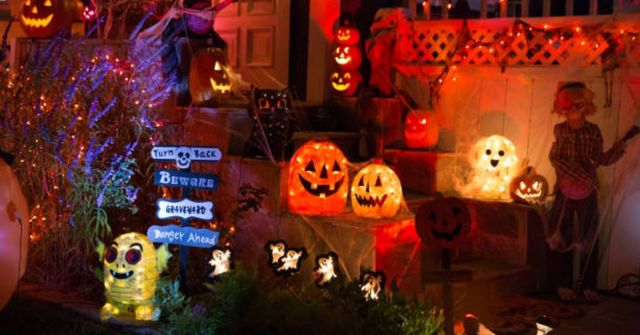 A Halloween party entrance decorated with string lights, decor candles and lanterns