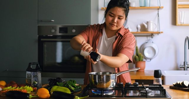 A woman is preparing Thanksgiving dishes for their Thanksgiving dinner