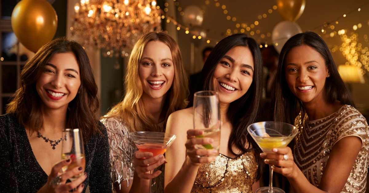 4 women is cheering with their drinks at a beautifully decorated party