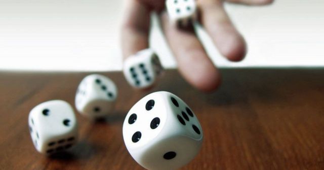 A participant rolls a dice in a Thanksgiving dinner game