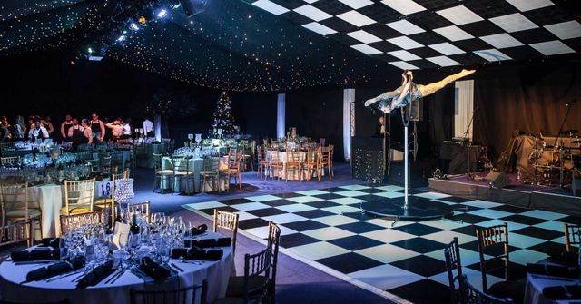 Elegantly set tables surround a black-and-white checkered dance floor