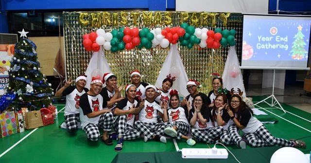 A joyful group dressed in matching pajamas poses for a Christmas party photo