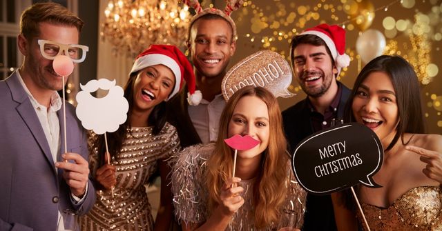A group of employees taking photos with fun props at an office Christmas party