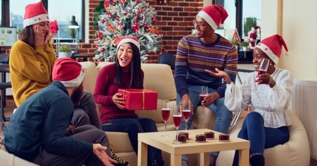 A group of colleagues playing Pass the Parcel as nwork Christmas party games