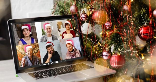 Laptop displaying a virtual Christmas gathering with six people wearing Santa hats