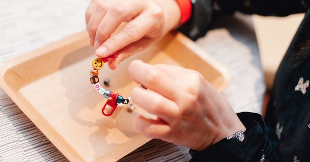 An event participant assembles their beaded keychain