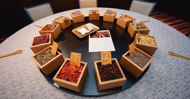 Circular display of open boxes filled with various dried herbs for a scented pouch workshop