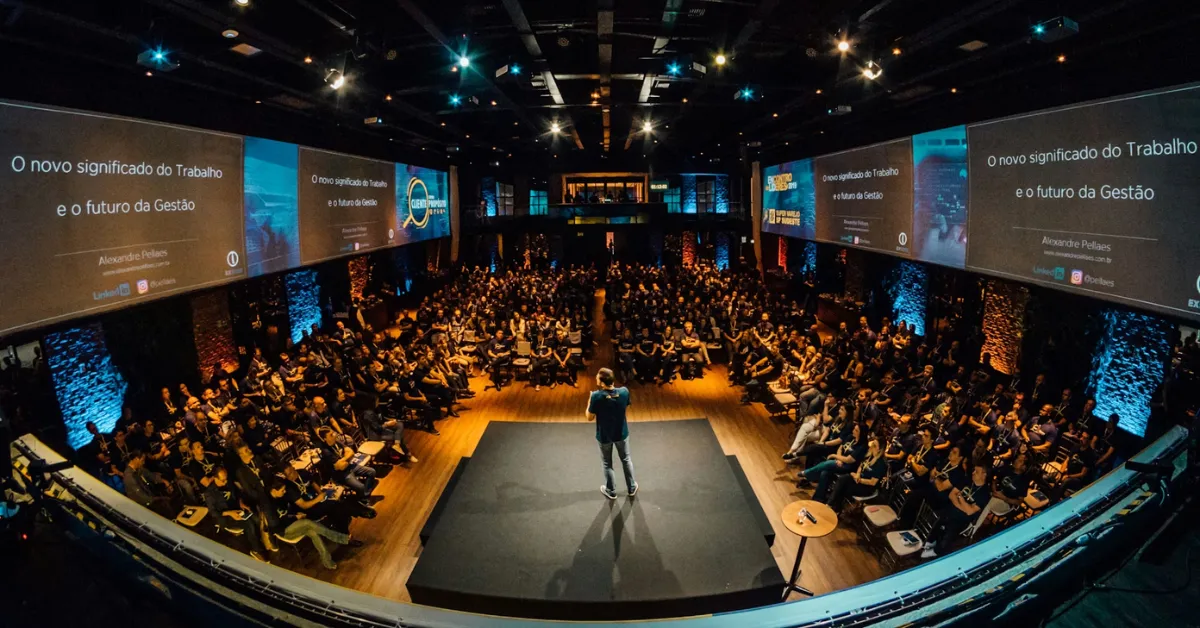 A speaker stands on stage at a corporate conference