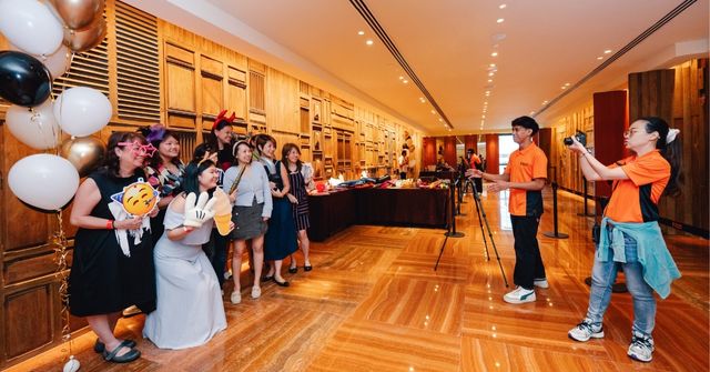 A group of event attendees joyfully participate in Dream Station's event photobooth