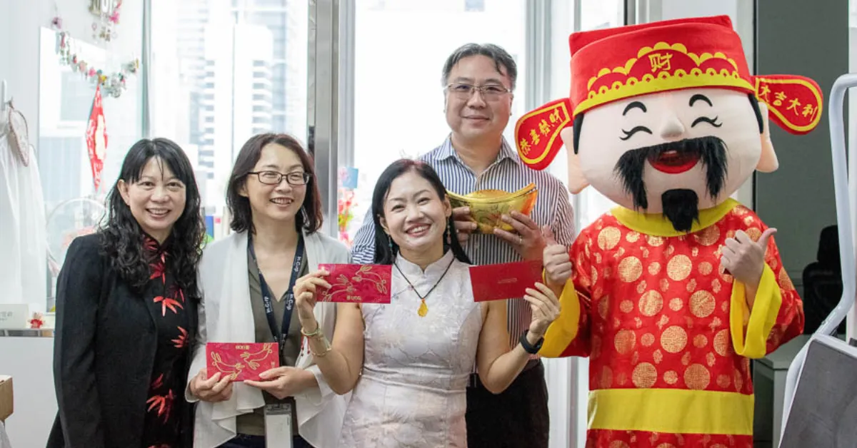 A group of four coworkers exchanging red packets as a Lunar New Year party idea