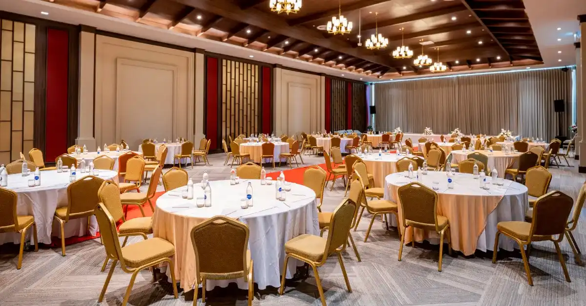 A banquet hall with round tables set for a corporate event