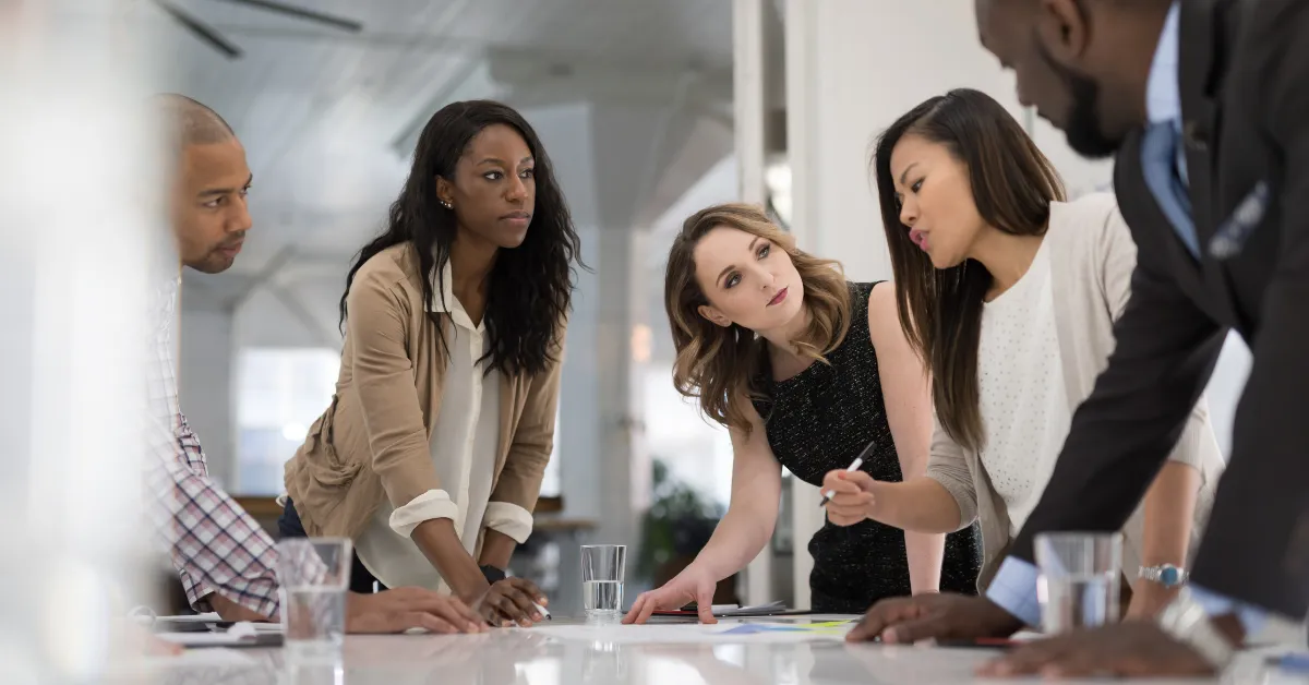 A group of five colleagues engaged in corporate event planning meeting