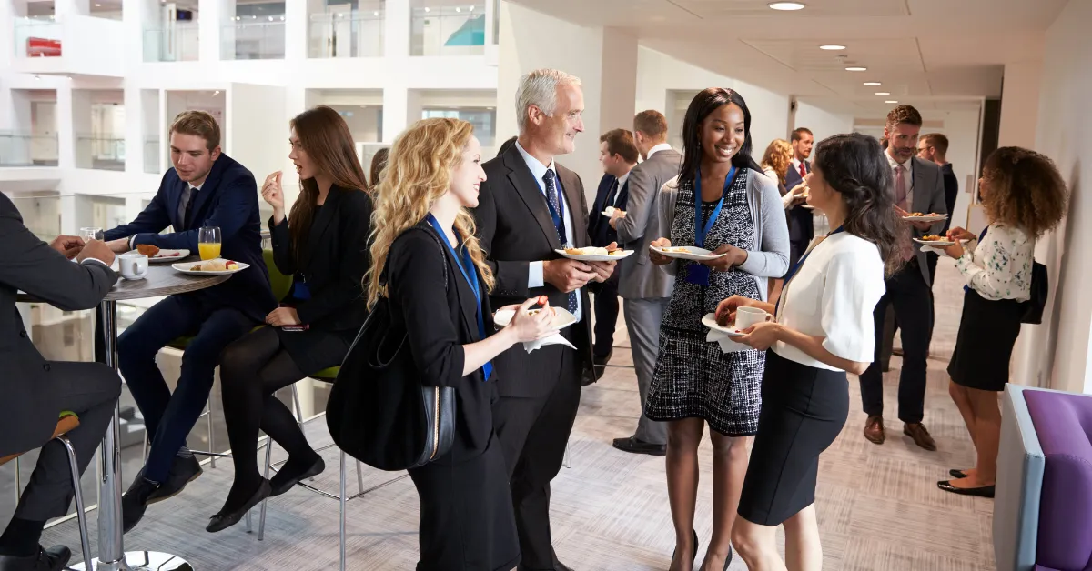 A diverse group of professionals interact at a networking event in a bright, modern space