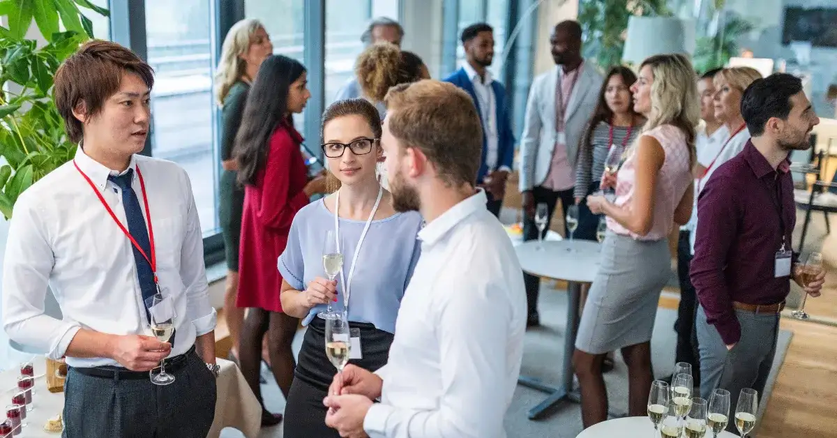 A group of professionally dressed people mingling at a corporate event