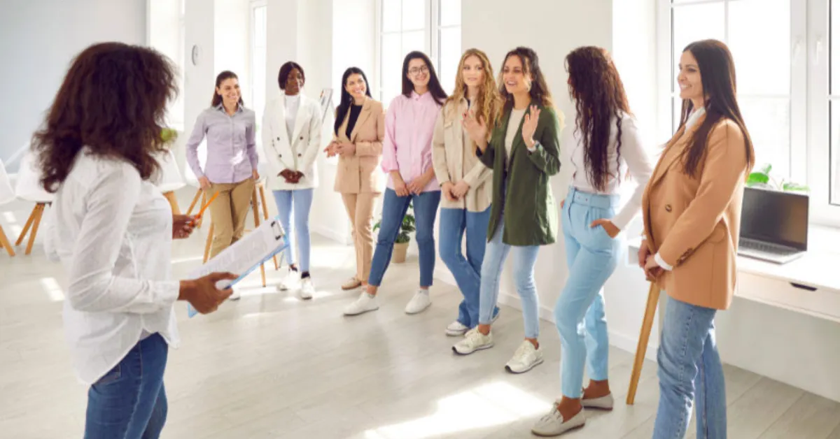 A group of eight professionally dressed women participating in the “build-a-story" icebreaker activity