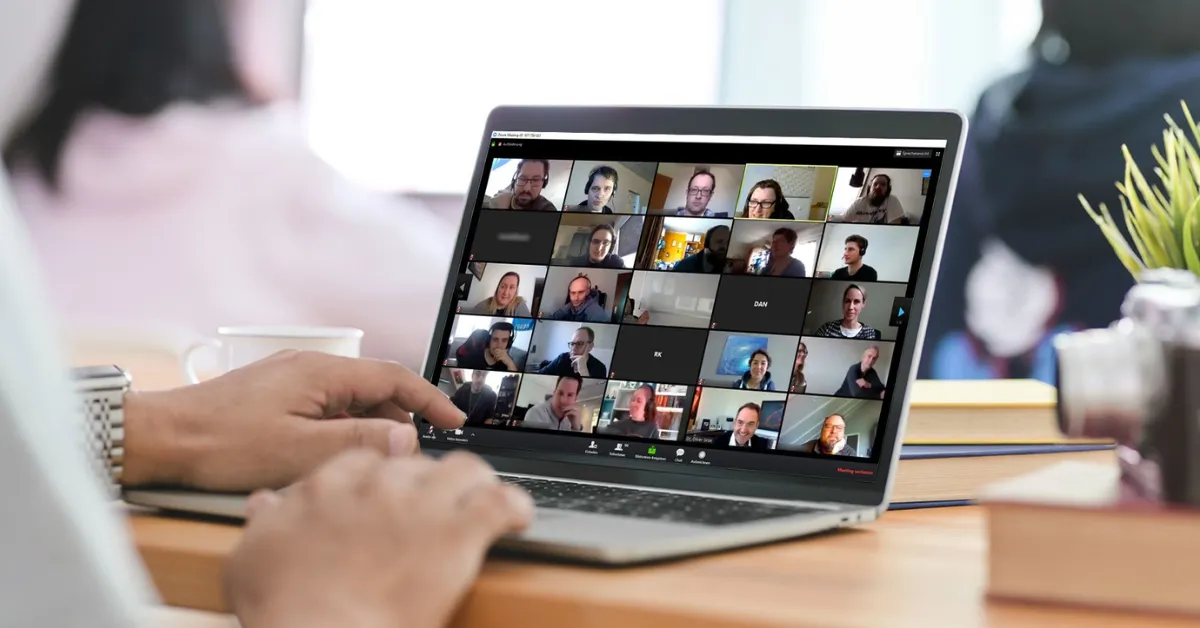 Laptop on a desk displaying an online seminar with multiple participants