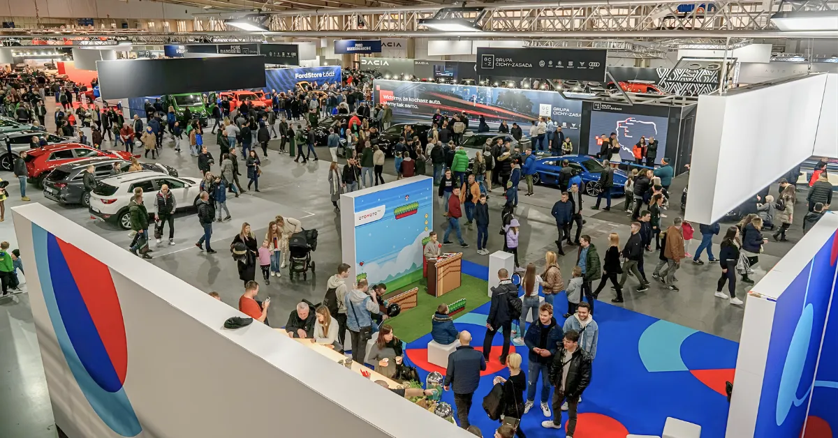 A bustling car exhibition with diverse attendees exploring various car displays.