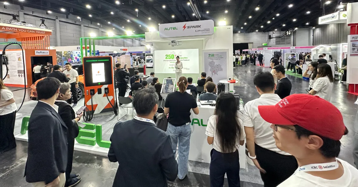 A bustling trade show booth features a presentation with an audience fully engaged