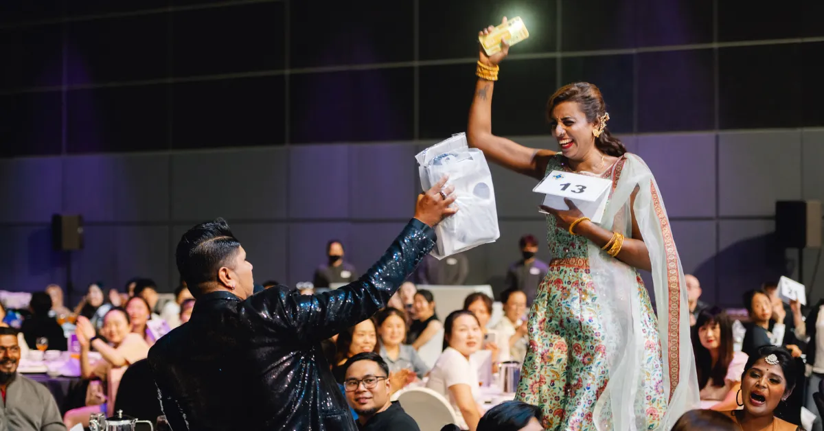 A female guest happily jumping because she's won a prize from the lucky draw game